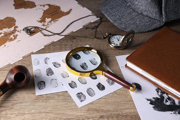 Magnifying glass with fingerprints, map and hat