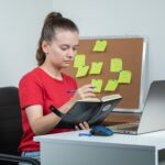 female-employee-working-laptop-taking-notes (1)