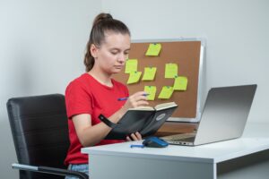 female-employee-working-laptop-taking-notes (1)